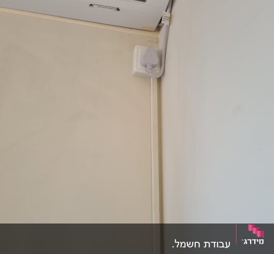 יחידת מיזוג אוויר עם חיבור חשמלי על הקיר
